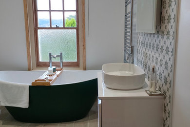 Large victorian bathroom in Surrey with white cabinets, a freestanding bath, a corner shower, green tiles, white walls, porcelain flooring, a console sink, a sliding door, a single sink and a floating vanity unit.