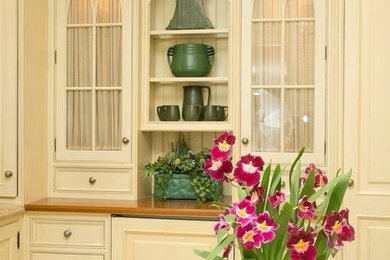 Mid-sized elegant l-shaped eat-in kitchen photo in New York with raised-panel cabinets, white cabinets, wood countertops and no island
