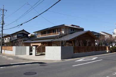 Idées déco pour une façade de maison asiatique de taille moyenne et à un étage avec un toit à deux pans et un toit en métal.