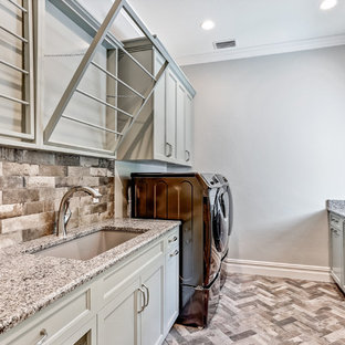 Design ideas for a medium sized traditional galley utility room in Tampa with a submerged sink, recessed-panel cabinets, grey cabinets, granite worktops, grey walls, porcelain flooring, a side by side washer and dryer, multi-coloured floors and multicoloured worktops.