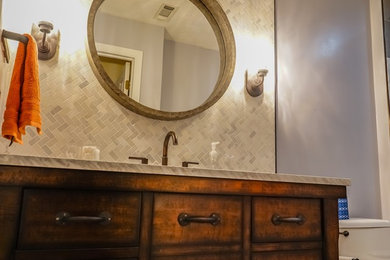 Example of a small urban gray tile and porcelain tile porcelain tile and gray floor bathroom design in Atlanta with furniture-like cabinets, distressed cabinets, a two-piece toilet, gray walls, an undermount sink and marble countertops