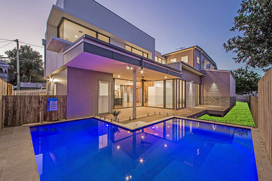 Design ideas for a large transitional backyard l-shaped pool in Brisbane with tile.