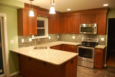 Eat-in kitchen - mid-sized craftsman u-shaped ceramic tile eat-in kitchen idea in Baltimore with an undermount sink, shaker cabinets, medium tone wood cabinets, granite countertops, glass tile backsplash and stainless steel appliances
