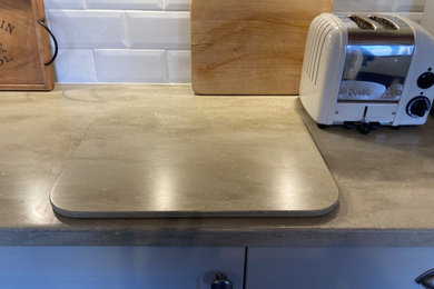 サセックスにあるコンテンポラリースタイルのおしゃれなダイニングキッチン (人工大理石カウンター、グレーのキッチンカウンター) の写真