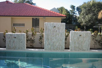 Design ideas for a modern backyard garden in Sunshine Coast with a water feature.