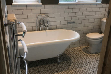 Design ideas for a medium sized classic grey and white bathroom in Other with a claw-foot bath, a corner shower, a two-piece toilet, white tiles, metro tiles, grey walls, cement flooring, a pedestal sink, multi-coloured floors, a sliding door and a single sink.