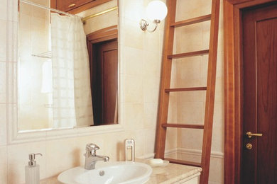 Источник вдохновения для домашнего уюта: маленькая главная ванная комната в классическом стиле с белыми фасадами, полновстраиваемой ванной, унитазом-моноблоком, бежевой плиткой, керамической плиткой, бежевыми стенами, полом из керамогранита, накладной раковиной, мраморной столешницей, коричневым полом и бежевой столешницей для на участке и в саду