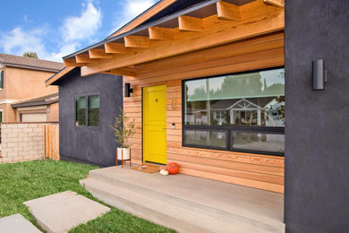 This is an example of a mid-sized midcentury one-storey black house exterior in Orange County with wood siding.
