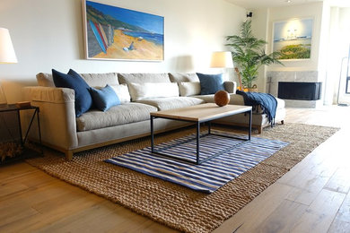 Inspiration for a mid-sized coastal open concept light wood floor living room remodel in Los Angeles with white walls, a standard fireplace, a stone fireplace and a concealed tv