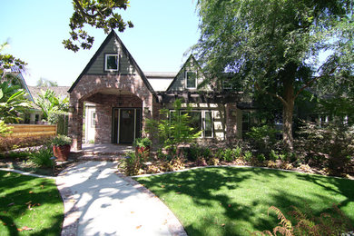 Mid-sized transitional two-storey brick red house exterior in Sacramento with a gable roof and a shingle roof.
