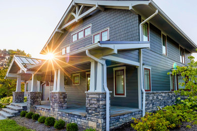 Mid-sized arts and crafts stone porch idea in Cleveland with a roof extension