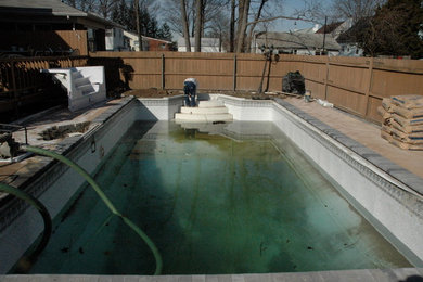 Large backyard concrete paver and rectangular pool photo in New York