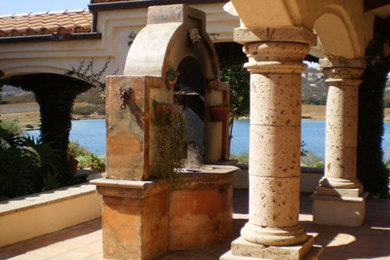 Patio - mid-sized mediterranean backyard tile patio idea in Los Angeles with a roof extension
