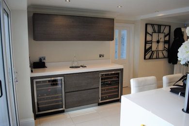 Photo of a large contemporary single-wall wet bar in Sussex with flat-panel cabinets, dark wood cabinets, quartzite benchtops, white splashback, porcelain floors, white floor and white benchtop.