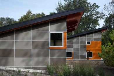 Example of a large trendy one-story wood exterior home design in Cedar Rapids with a shed roof
