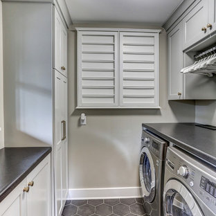 Inspiration for a small classic u-shaped separated utility room in Minneapolis with recessed-panel cabinets, white cabinets, laminate countertops, grey walls, ceramic flooring, a side by side washer and dryer, grey floors and grey worktops.