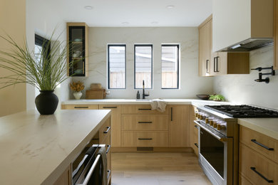 Mid-sized trendy l-shaped light wood floor open concept kitchen photo in Vancouver with an undermount sink, shaker cabinets, light wood cabinets, quartz countertops, beige backsplash, quartz backsplash, paneled appliances, an island and beige countertops