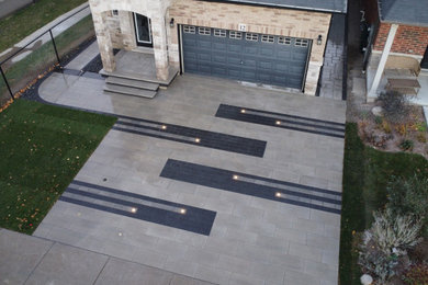 This is an example of a mid-sized modern front yard brick driveway in Toronto.