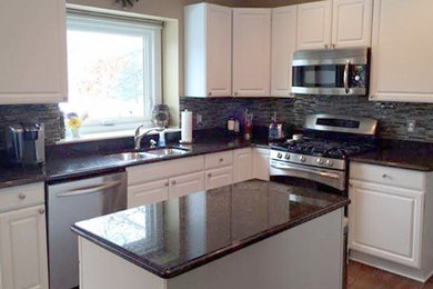 Photo of a mid-sized traditional l-shaped eat-in kitchen in Detroit with a double-bowl sink, white cabinets, granite benchtops, multi-coloured splashback, mosaic tile splashback, stainless steel appliances and with island.