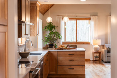 Mid-sized transitional l-shaped light wood floor eat-in kitchen photo in Burlington with an undermount sink, shaker cabinets, medium tone wood cabinets, quartz countertops, beige backsplash, subway tile backsplash, stainless steel appliances, a peninsula and white countertops