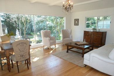 This is an example of a mid-sized traditional open concept family room in San Francisco with light hardwood floors, beige walls, no fireplace and no tv.