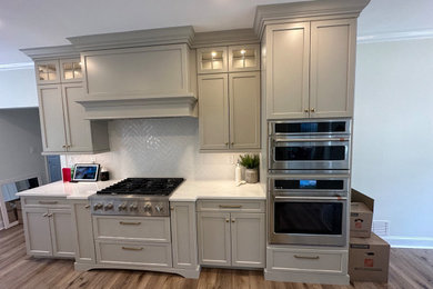Eat-in kitchen - mid-sized transitional galley vinyl floor and beige floor eat-in kitchen idea in Philadelphia with a farmhouse sink, shaker cabinets, gray cabinets, quartz countertops, white backsplash, ceramic backsplash, stainless steel appliances, an island and white countertops