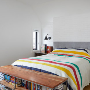 Idee per una piccola camera matrimoniale chic con pareti bianche, parquet chiaro, pavimento marrone e pareti in mattoni
