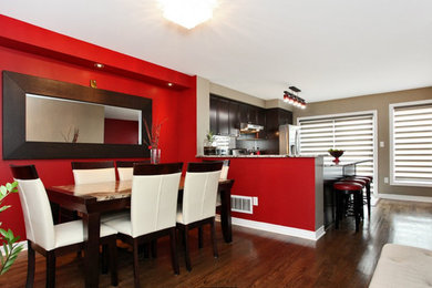 Example of a mid-sized transitional medium tone wood floor and brown floor kitchen/dining room combo design in Toronto with red walls