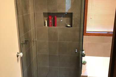 Photo of a small master bathroom in Melbourne with a drop-in tub and ceramic tile.
