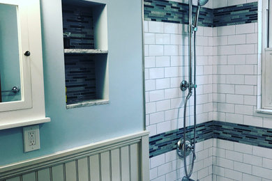 Example of a mid-sized minimalist white tile and ceramic tile ceramic tile, gray floor, single-sink and wainscoting bathroom design in Boston with shaker cabinets, white cabinets, a hot tub, a two-piece toilet, blue walls, an undermount sink, marble countertops, white countertops, a niche and a built-in vanity