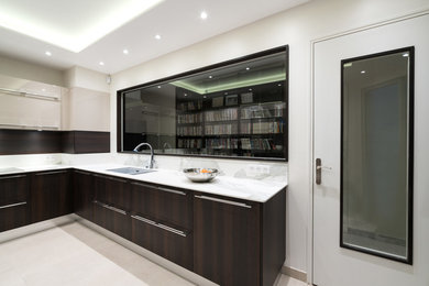 Exemple d'une cuisine tendance en U et bois brun fermée et de taille moyenne avec un évier intégré, un placard à porte plane, un plan de travail en quartz, une crédence grise, un électroménager en acier inoxydable, un sol en carrelage de céramique, aucun îlot et un sol beige.