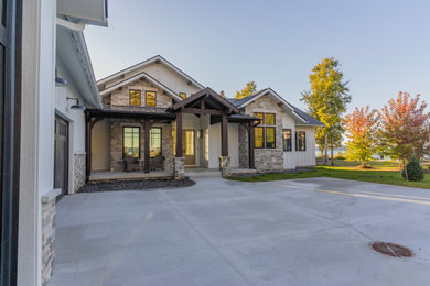 Example of a mid-sized transitional white concrete fiberboard and board and batten gable roof design in Grand Rapids with a mixed material roof