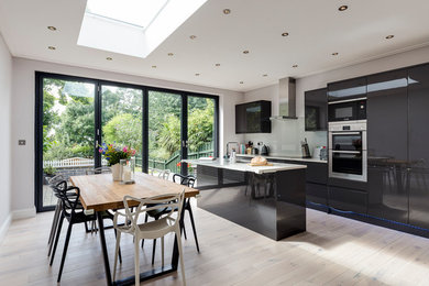 Inspiration for a medium sized contemporary kitchen/diner in London with flat-panel cabinets, black cabinets, marble worktops, multiple islands and white worktops.