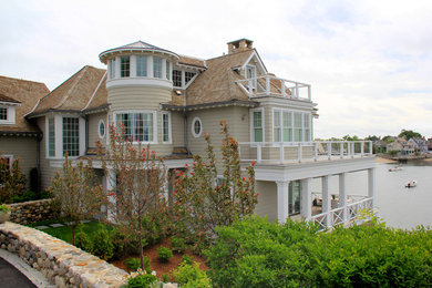 Beach style three-storey beige exterior in New York with wood siding.