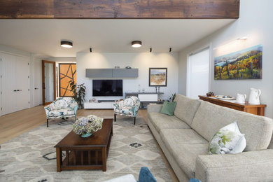 Contemporary open plan living room in Hamilton with light hardwood flooring, a wall mounted tv and a vaulted ceiling.