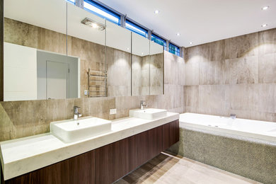Design ideas for a modern bathroom in Sunshine Coast with dark wood cabinets, engineered quartz benchtops and gray tile.