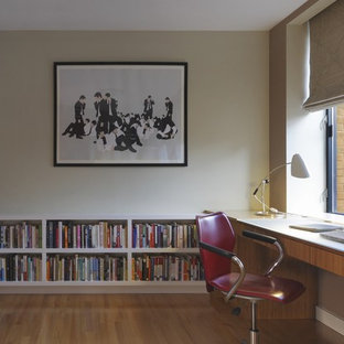 ニューヨークの大きいモダンスタイルのおしゃれな書斎 (ベージュの壁、無垢フローリング、自立型机) の写真