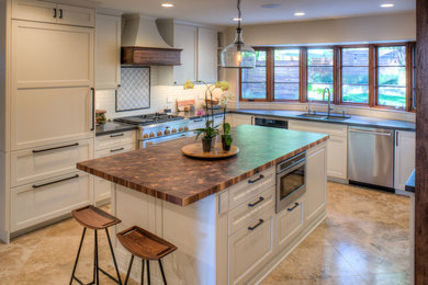 Example of a mid-sized cottage u-shaped travertine floor and beige floor open concept kitchen design in Denver with an undermount sink, recessed-panel cabinets, white cabinets, quartzite countertops, white backsplash, subway tile backsplash, stainless steel appliances and an island