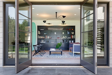 Living room library - huge modern open concept slate floor and gray floor living room library idea in New York with white walls