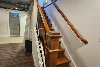 Basement - mid-sized modern underground laminate floor, brown floor and exposed beam basement idea in Other with a home theater and white walls