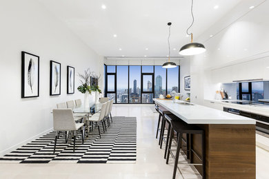Mid-sized modern single-wall open plan kitchen in Melbourne with a double-bowl sink, flat-panel cabinets, white cabinets, mirror splashback, stainless steel appliances, ceramic floors, with island, white floor and white benchtop.