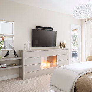 Großes Klassisches Hauptschlafzimmer mit grauer Wandfarbe, Teppichboden, Kamin und Kaminumrandung aus Holz in Miami
