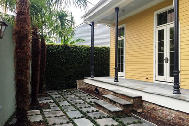 Example of a small arts and crafts yellow two-story vinyl gable roof design in New Orleans