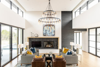Inspiration for a modern beige floor, tray ceiling and brick wall living room remodel in Austin with a tile fireplace