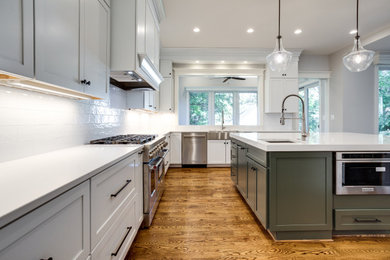 Large transitional l-shaped kitchen pantry photo in DC Metro with an undermount sink, quartz countertops, white backsplash, stainless steel appliances, an island and shaker cabinets
