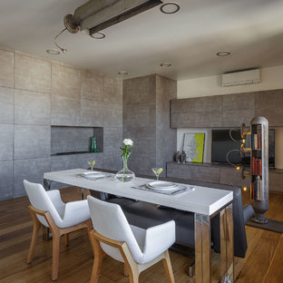 На фото: гостиная-столовая среднего размера в стиле лофт с серыми стенами, горизонтальным камином, коричневым полом и паркетным полом среднего тона с