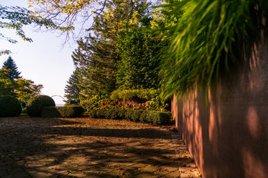 Photo of a large modern courtyard metal fence driveway in Toronto.