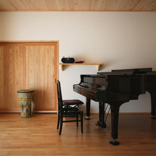 Großes Asiatisches Arbeitszimmer mit weißer Wandfarbe, braunem Holzboden, orangem Boden und Holzdecke in Sonstige
