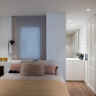 Ejemplo de dormitorio principal, contemporáneo, con paredes grises, suelo de madera en tonos medios y suelo marrón