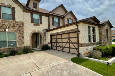 Large minimalist beige two-story brick and shingle exterior home photo in Austin with a shingle roof and a brown roof